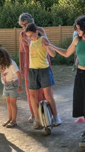 Premiers pas en famille Enfants s'initiant à la gyroroue solaire HelioEvents main dans la main dans un parc
